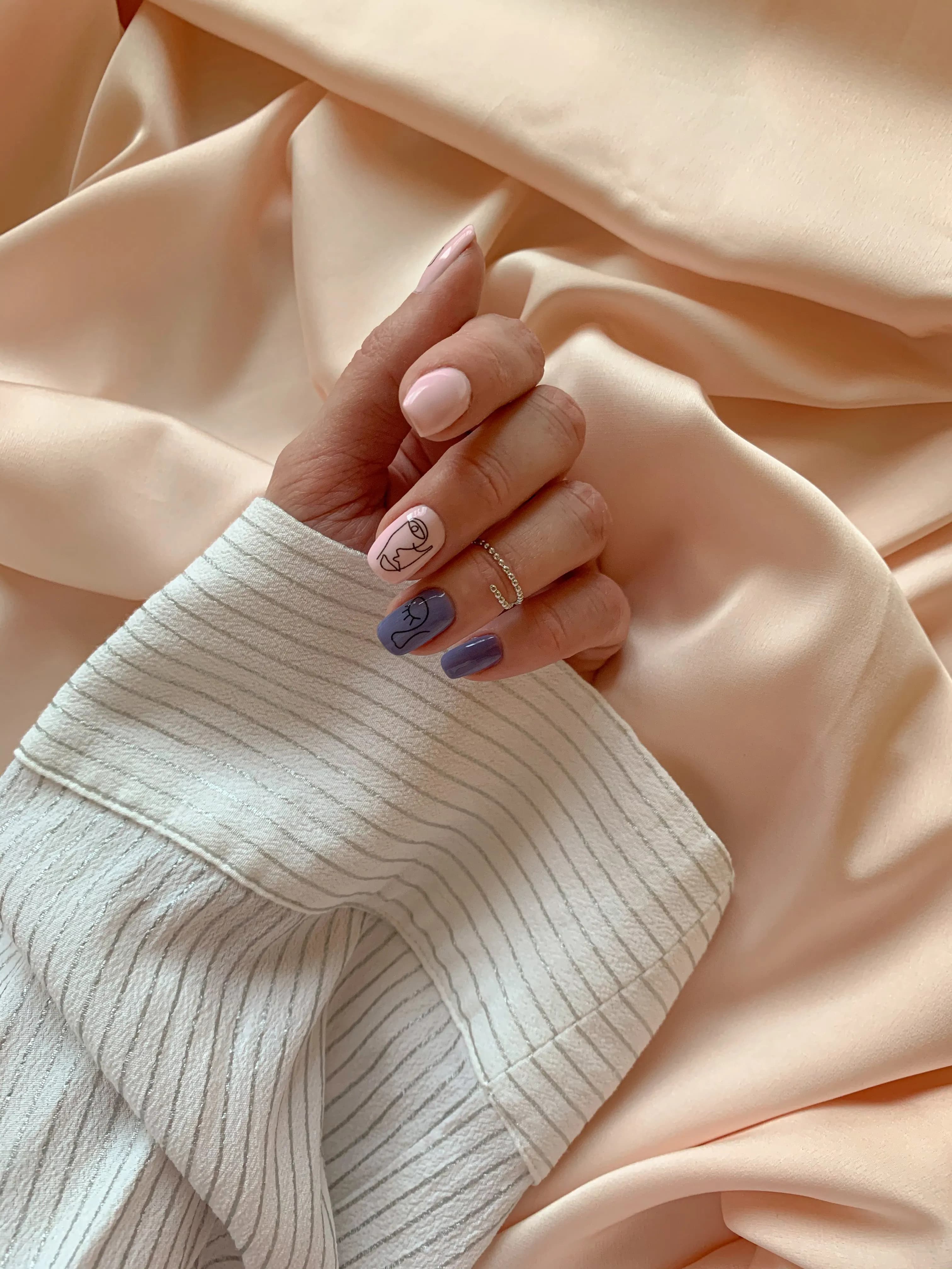 Mão com unhas delicadas sobre seda cor de pêssego